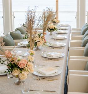 Elegante allestimento con centro tavola floreale e vista panoramica sul mare.