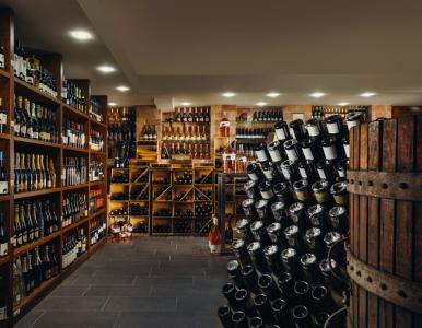 Cantina con scaffali di vini, champagne e bottiglie pregiate.