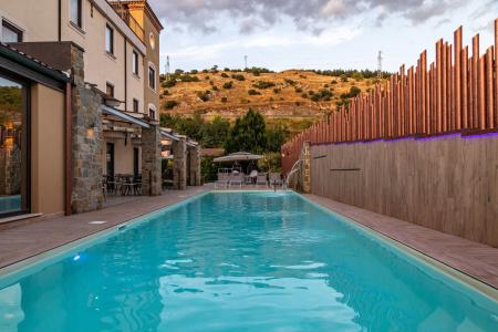 Piscina esterna dell’hotel, circondata da area relax, lettini e vista sulla natura circostante.
